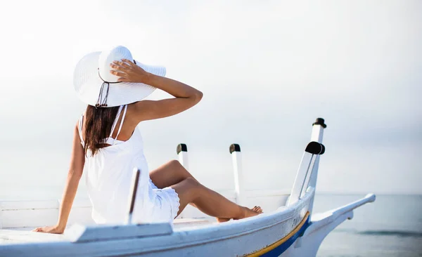 Jong meisje in de hoed zit in boot — Stockfoto