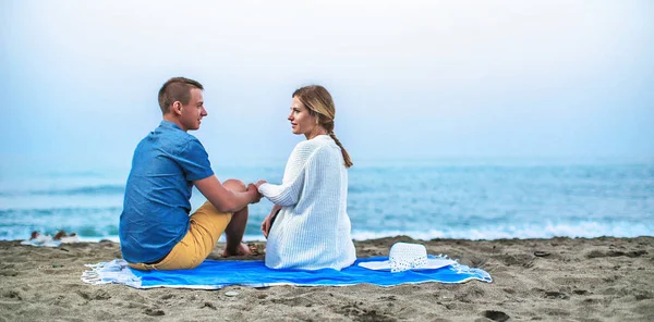 Young couple enjoying romantic evening on the beach — Stock Photo, Image