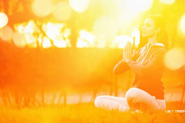 Yoga-Frau meditiert bei Sonnenuntergang — Stockfoto
