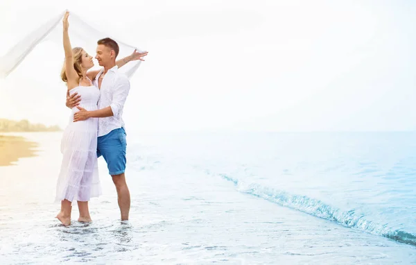 Счастливая молодая пара наслаждается морем — стоковое фото