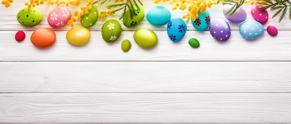Ovos de Páscoa com flores no fundo de madeira — Fotografia de Stock