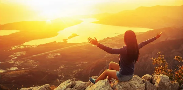 Ευτυχισμένη γυναίκα στα βουνά κοιτάζοντας το ηλιοβασίλεμα — Φωτογραφία Αρχείου
