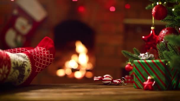 Pies en calcetines de lana junto a la chimenea de Navidad. Concepto de vacaciones de invierno — Vídeos de Stock