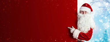 Santa Claus Showing Something On a Red Wall clipart