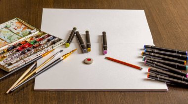 Çocukların yaratıcılığı ve çizim boyası albümü için araçlar, suluboya boyalar, basit kalem, renk kalemleri, tahta bir yüzeye silgi