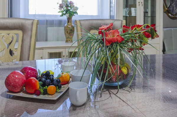 Home still life with fruits, flowers and kitchenware. Home decoration, still life in the apartment. Fruit still life on the background of the interior