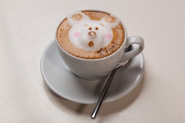 Kedi şeklinde köpüklü kahve ve kahverengi masanın üzerinde fare.