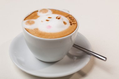 Kedi şeklinde köpüklü kahve ve kahverengi masanın üzerinde fare.