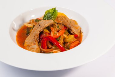 Soslu dana eti ve tabakta sebze.