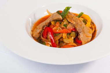 Soslu dana eti ve tabakta sebze.