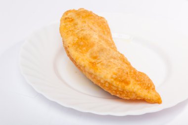 Bir cheburek, beyaz tabakta kuzu eti