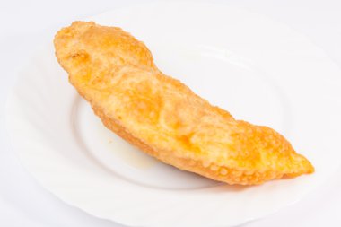 Bir cheburek, beyaz tabakta kuzu eti