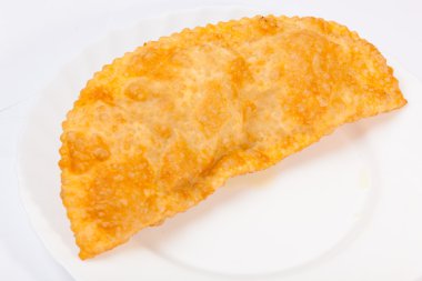 Bir cheburek, beyaz tabakta kuzu eti