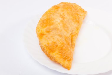 Bir cheburek, beyaz tabakta kuzu eti