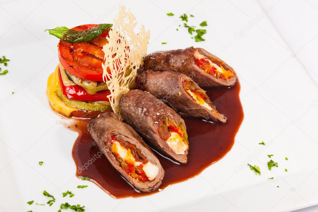 meat rolls with sauce and vegetables with cheese on plate