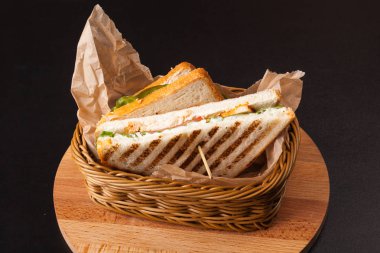 siyah bir zemin üzerine bir sepet içinde sandviç