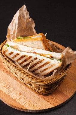 siyah bir zemin üzerine bir sepet içinde sandviç