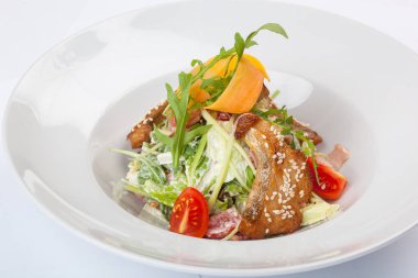 Beyaz tabakta pike soslu salata.