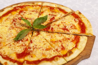 Masada beyaz arka planlı peynirli pizza.