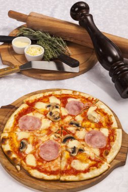 Beyaz arka planda pizza ve yemek takımlarıyla hayat devam ediyor