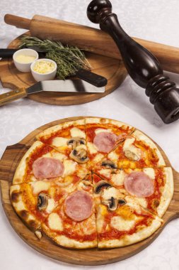 Beyaz arka planda pizza ve yemek takımlarıyla hayat devam ediyor