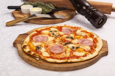 Beyaz arka planda pizza ve yemek takımlarıyla hayat devam ediyor