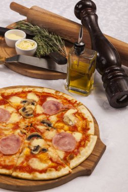 Beyaz arka planda pizza ve yemek takımlarıyla hayat devam ediyor