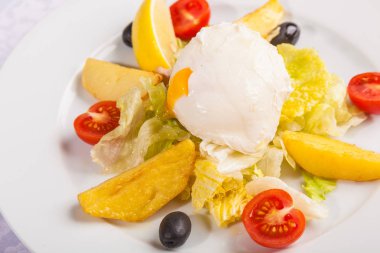 Beyaz tabakta saban süren yumurta salatası.