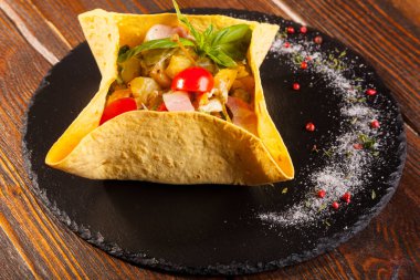 Siyah tabakta mısır ve tortilla salatası.