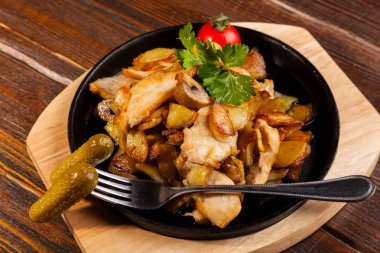 Siyah tavada kızarmış patates ve mantar.