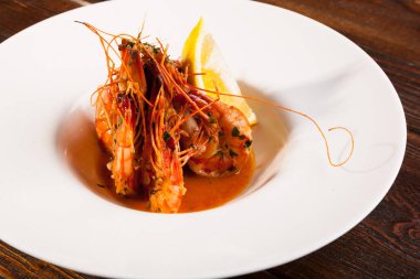 Beyaz tabakta limonlu kaplan karidesi