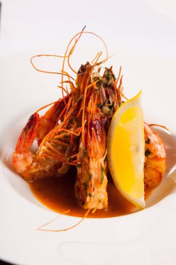 Beyaz tabakta limonlu kaplan karidesi