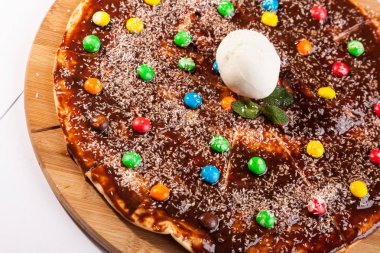 Tahta tabakta çikolatalı tatlı çocuk pizzası.