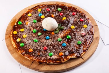 Tahta tabakta çikolatalı tatlı çocuk pizzası.