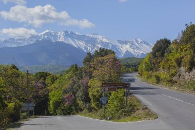 Dağlarda ilkbahar yolu ve mavi gökyüzü