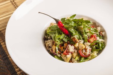 Arugula salatası ve beyaz tabakta vişneli domates.