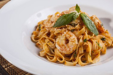 beyaz tabakta karidesli makarna