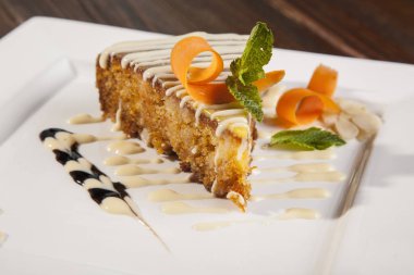 Beyaz tabakta süslemeli havuçlu kek.