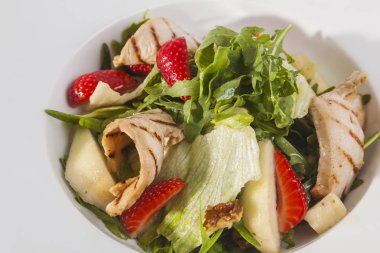 Beyaz plaka üzerinde ızgara tavuk salatası