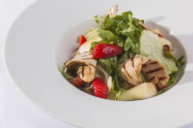 Beyaz plaka üzerinde ızgara tavuk salatası