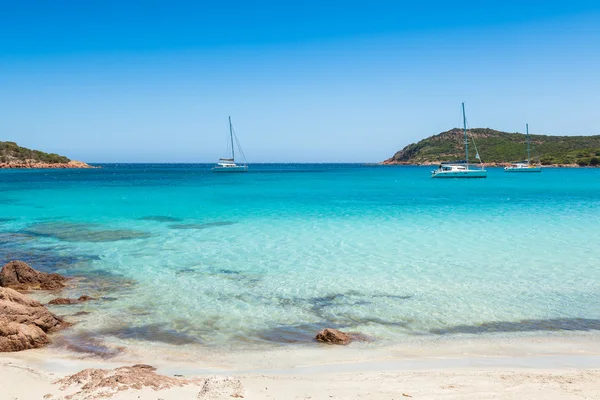 Boats mooring in the turquoise water of  Rondinara beach in Cors — Stock Photo, Image