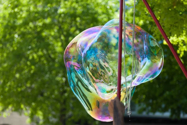 Arstist soufflant des bulles de savon géant coloré en plein air — Photo