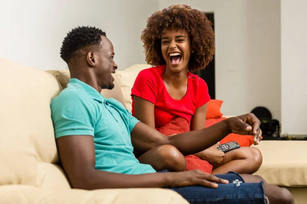 Černošky africký pár sledování televize v obývacím pokoji — Stock fotografie