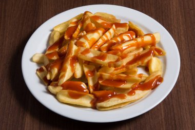 Üst tabakta üst tabakta, tabakta patates kızartması, domates sosu ve küçük kaselerde mayonez, küçük kaselerde domates sosu.