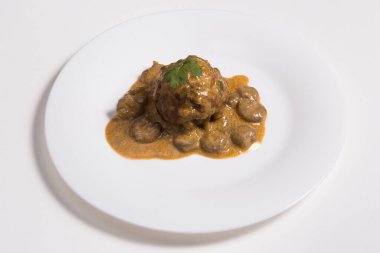 Beyaz arka planda bir tabakta karides ve et suyu ile Latin Amerika ana yemek mofongosu