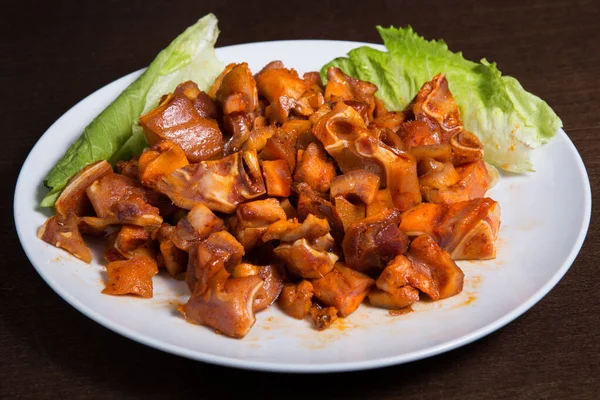 Spanish dish, smoked pork ears in a white plate