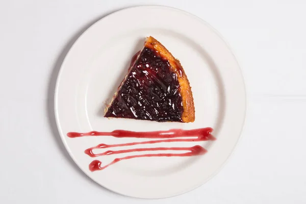 白盘白盘上夹着黑醋栗和蓝莓酱的芝士蛋糕 — 图库照片