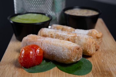 Tequenos adında, peynirle dolu kızarmış mısırdan yapılmış Latin Amerika mezeleri.