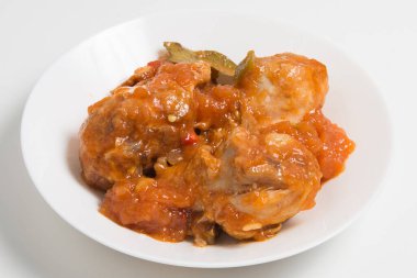 Yumuşak soslu kemiksiz tavuk butları ve beyaz tabakta otlar.