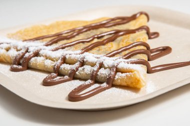 Beyaz tabakta fındıklı çikolatalı leziz krep.